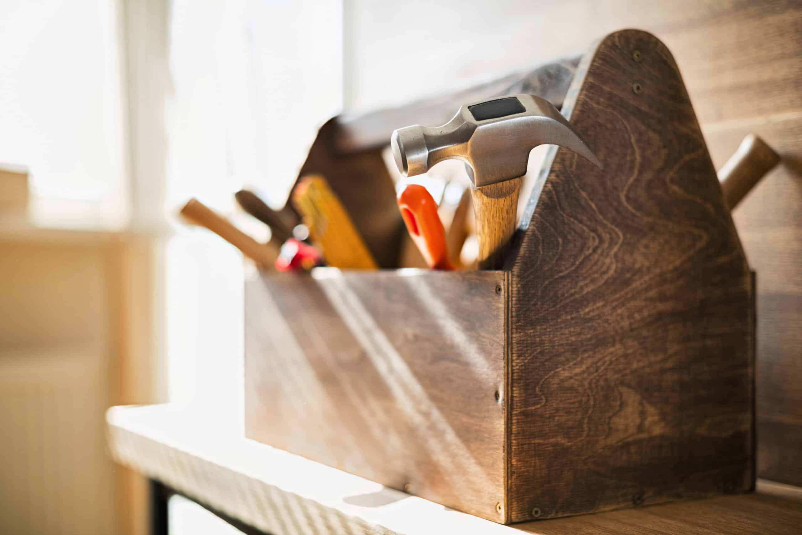 Hand tools stored in a brown wooden toolbox