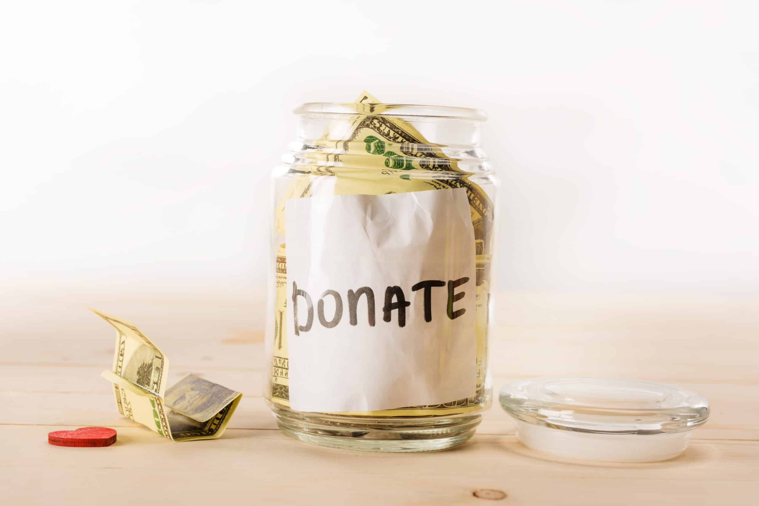 How To Donate To Charity When You Don't Have The Cash 1 Glass jar with white "Donate" label stuffed with $100 bills to donate to charity