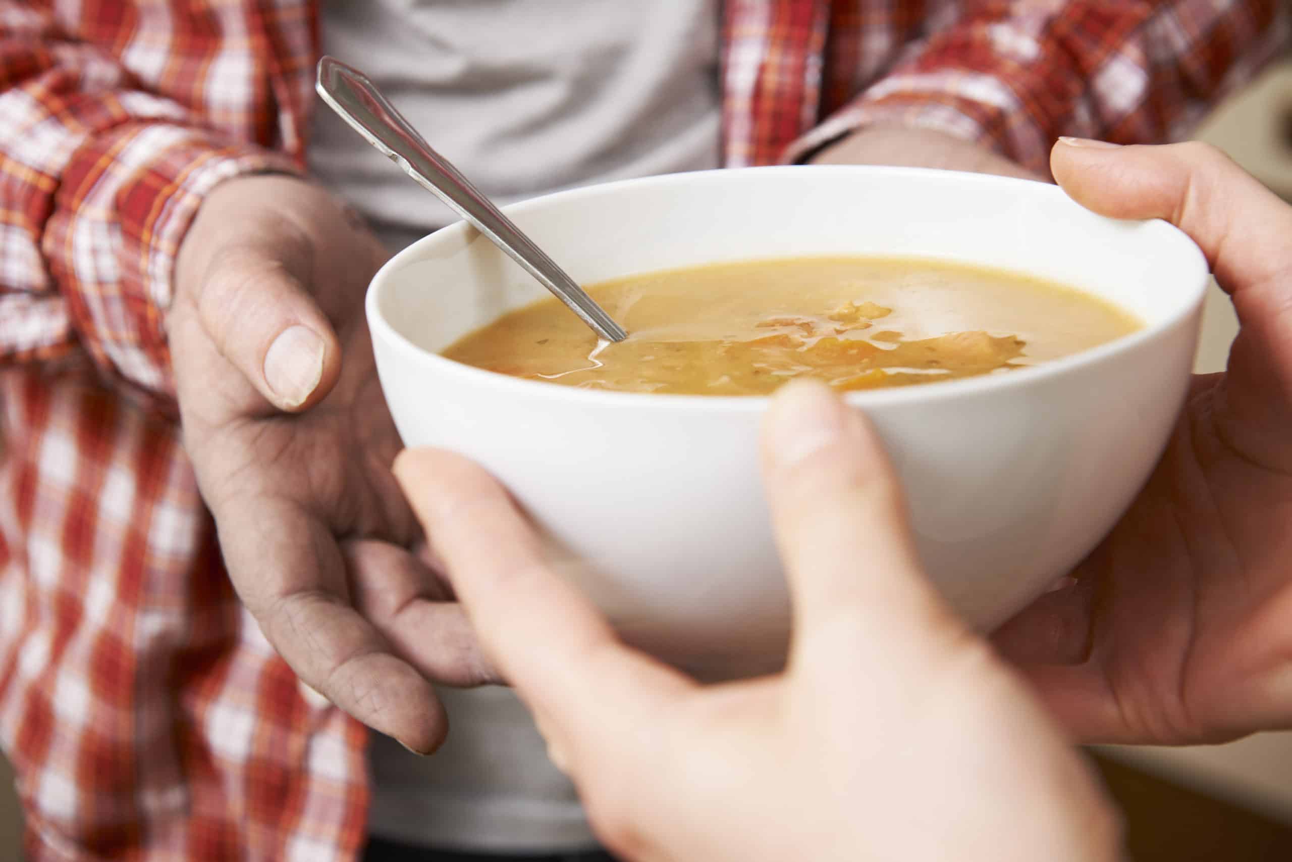 How To Donate To Charity When You Don't Have The Cash 4 Woman working at a soup kitchen to donate to charity handing food to a needy man