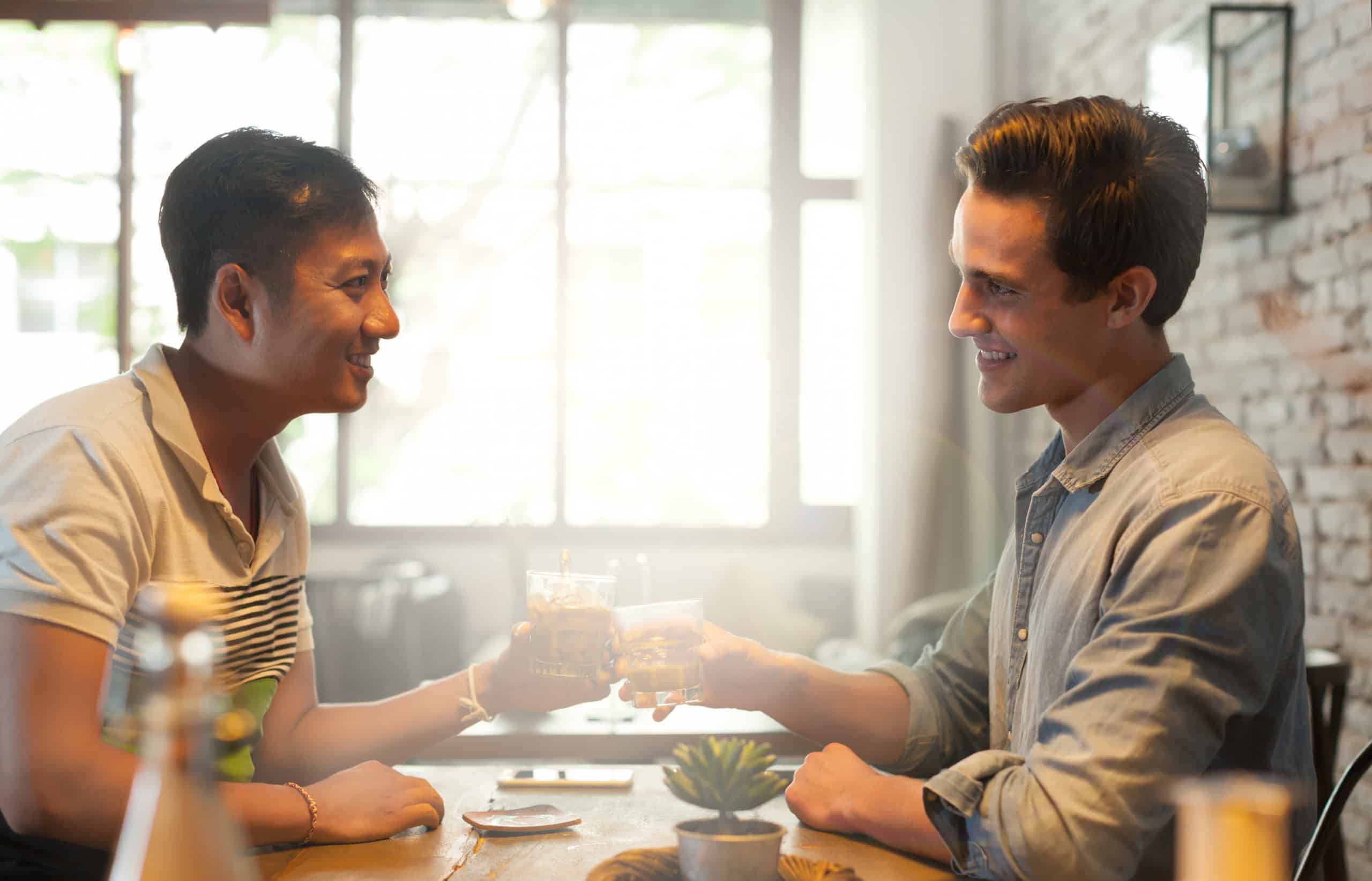 Gay male couple toasting on a first date