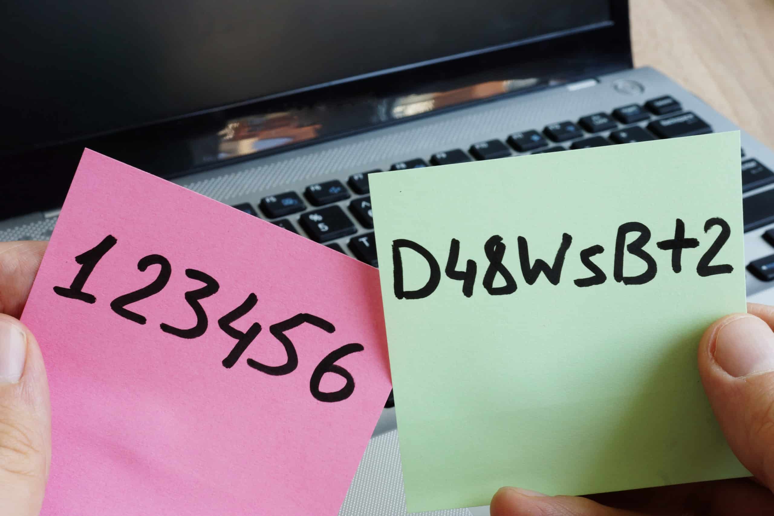 Strong password on a green sticky note and weak password on a pink sticky note.