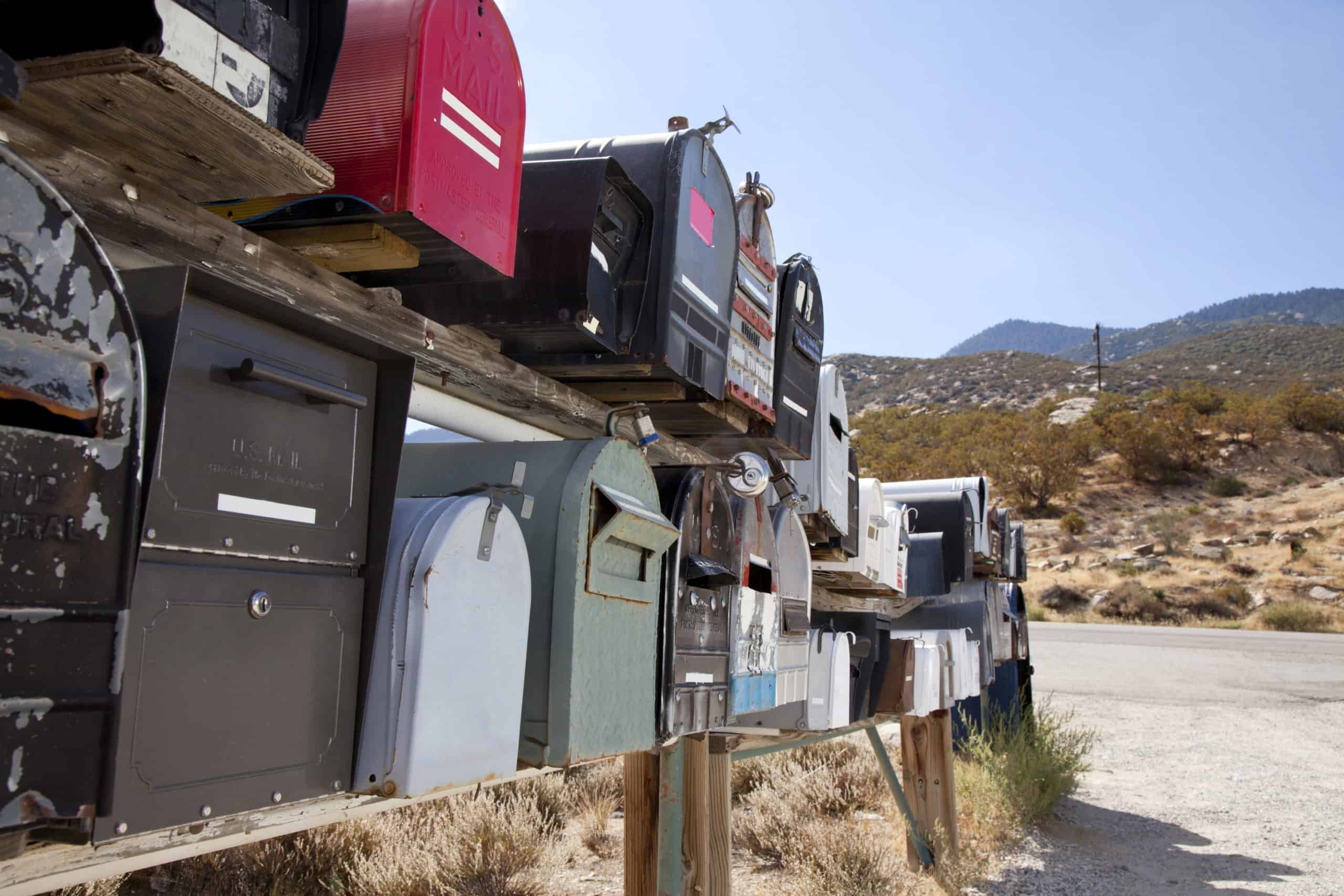 Rows of mailboxes open to identity theft on the side of a rural road.
