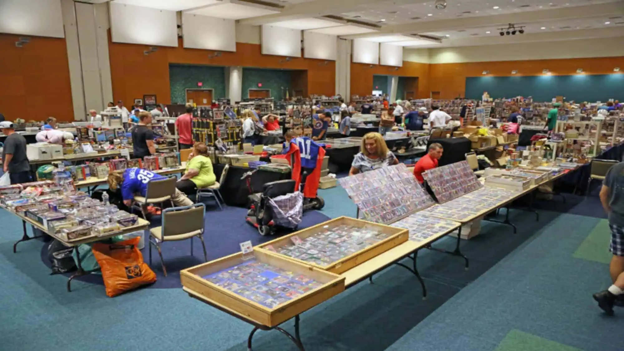 People investing in collectibles at a trade show buying and selling Pokemon cards, comic books, sports cards and more.