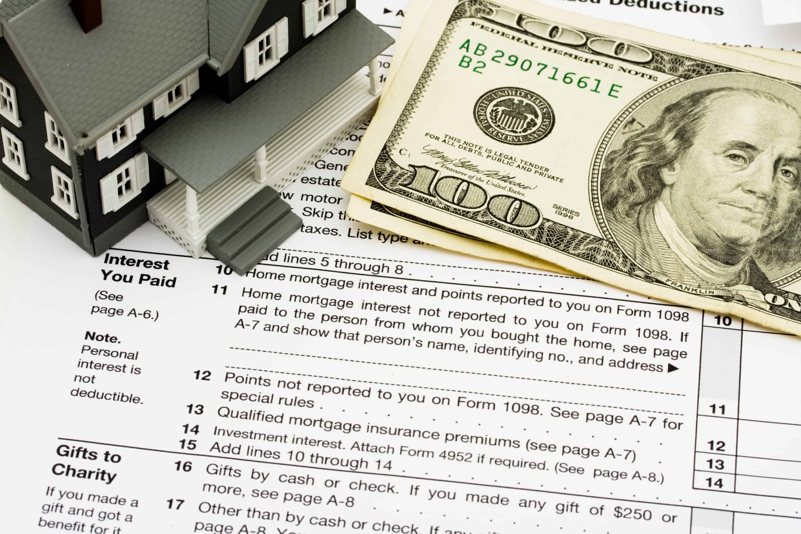 Tax Deductions: Bad Advice To Avoid 4 Hundred dollar bills and a model house laid on top of Form 1040 Schedule A