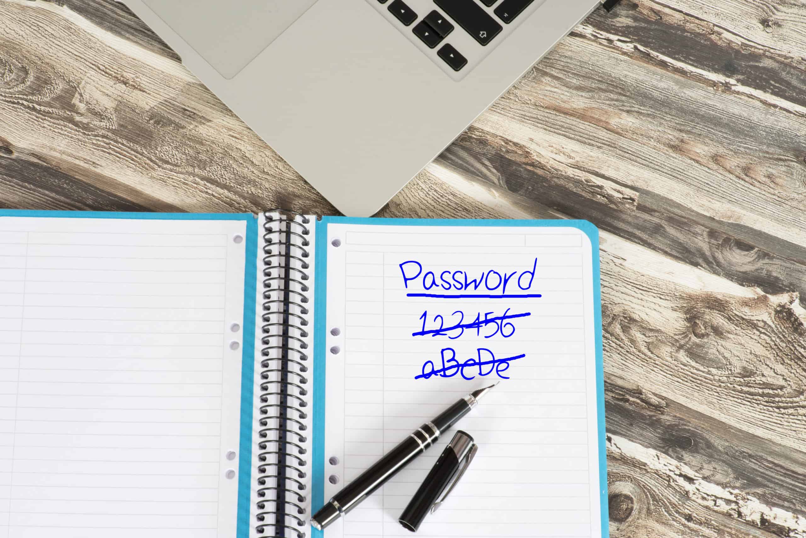Passwords written and crossed out with a blue ink fountain pen in a notebook--could really use LastPass password manager.