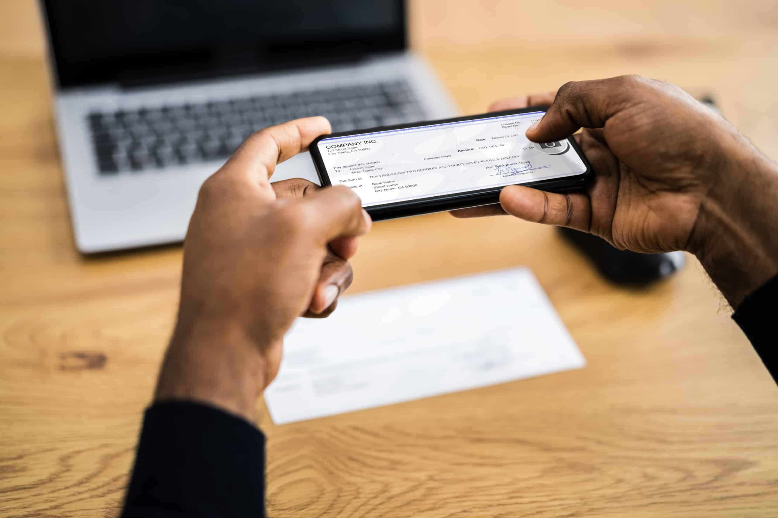 Black man making a mobile check deposit to a bank account at his preferred financial institution