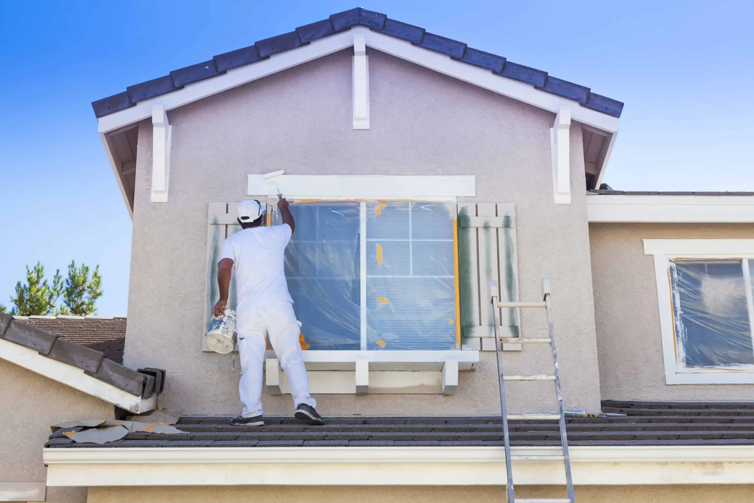 Busy House Painter Painting the Trim And Shutters of A Home.