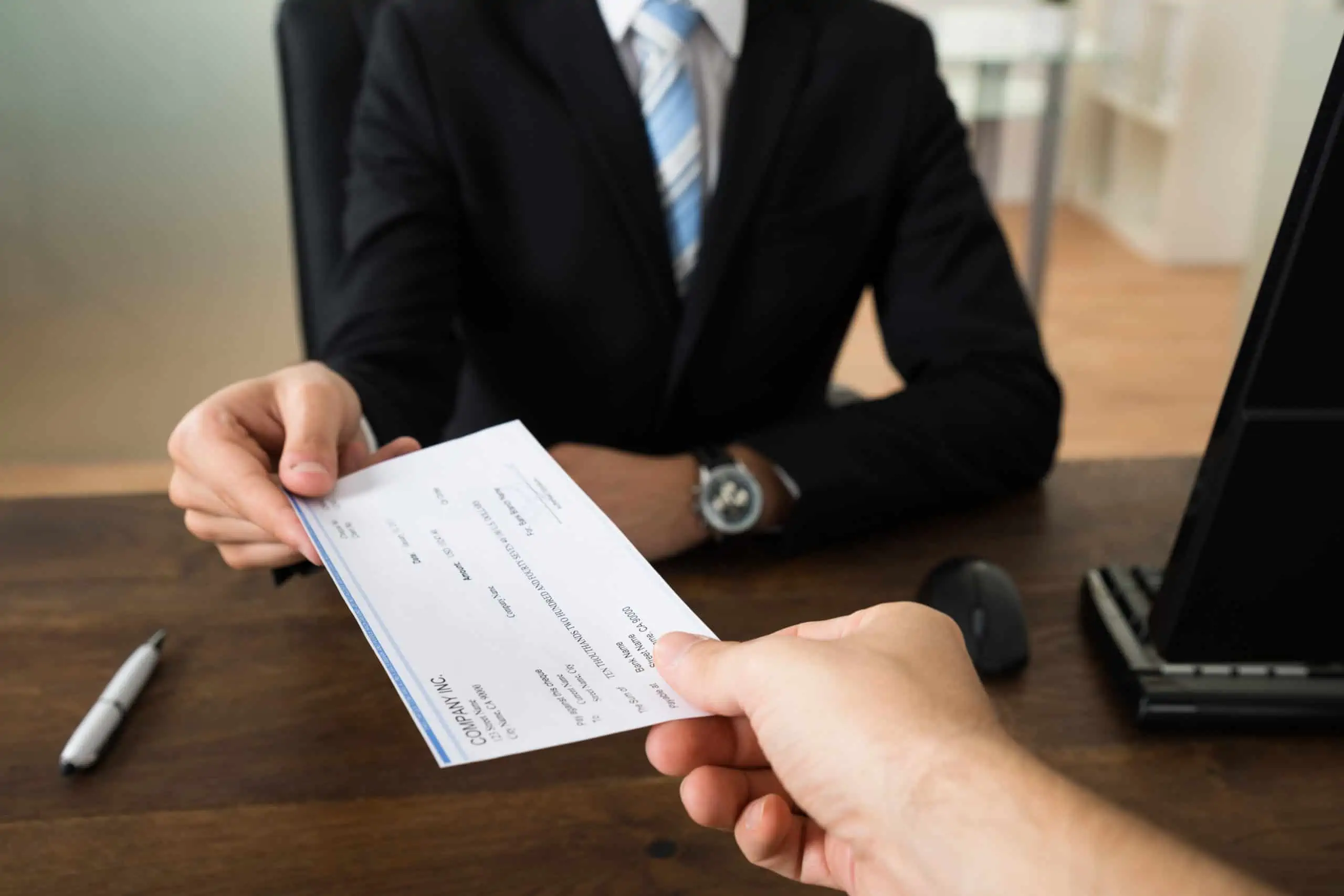 Handing tax preparer a check to pay for individual income tax return preparation