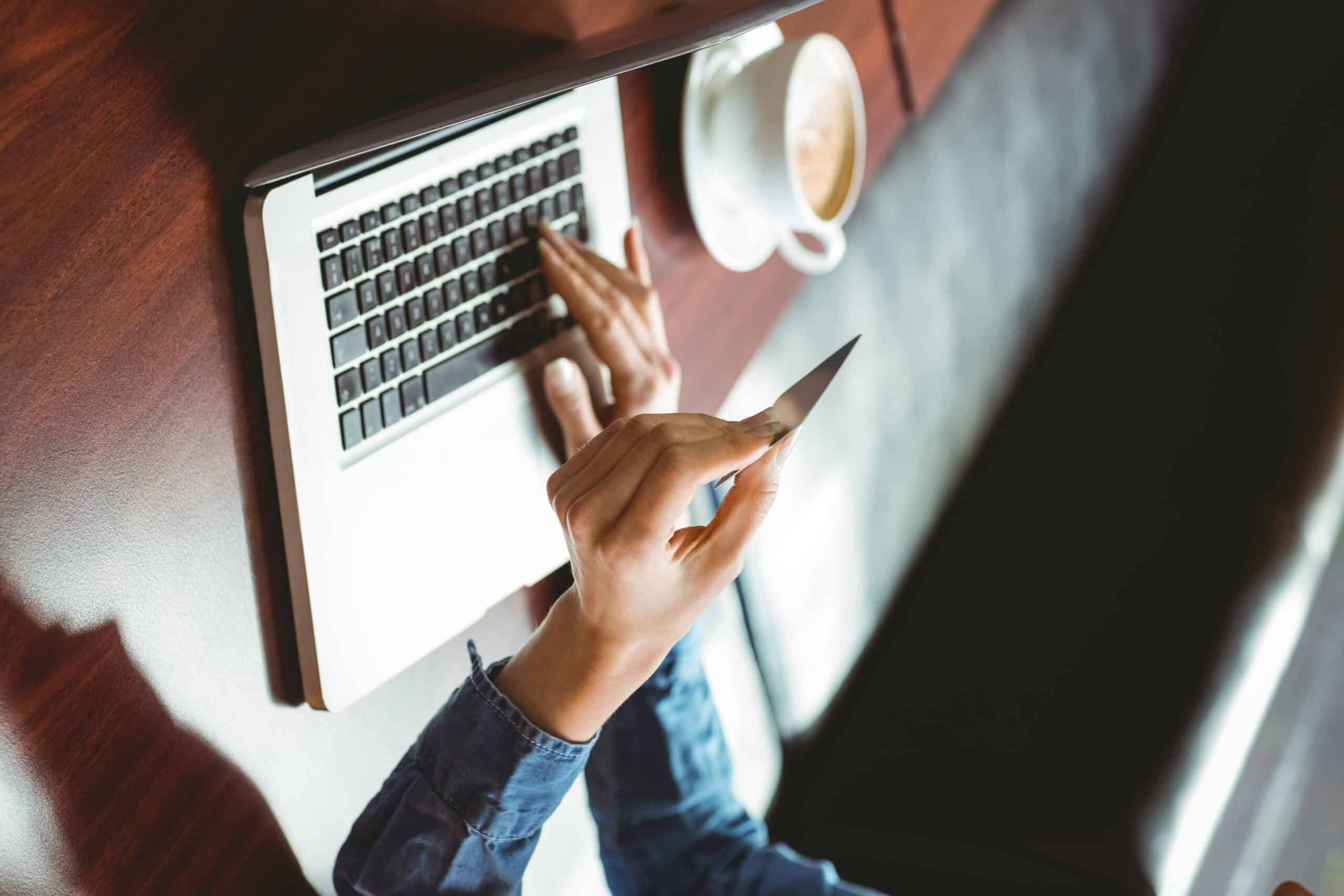 3 Ways To Prevent Free Trials From Costing You Money 1 Caucasian woman entering her credit card info for a free trial on a laptop in a coffee shop