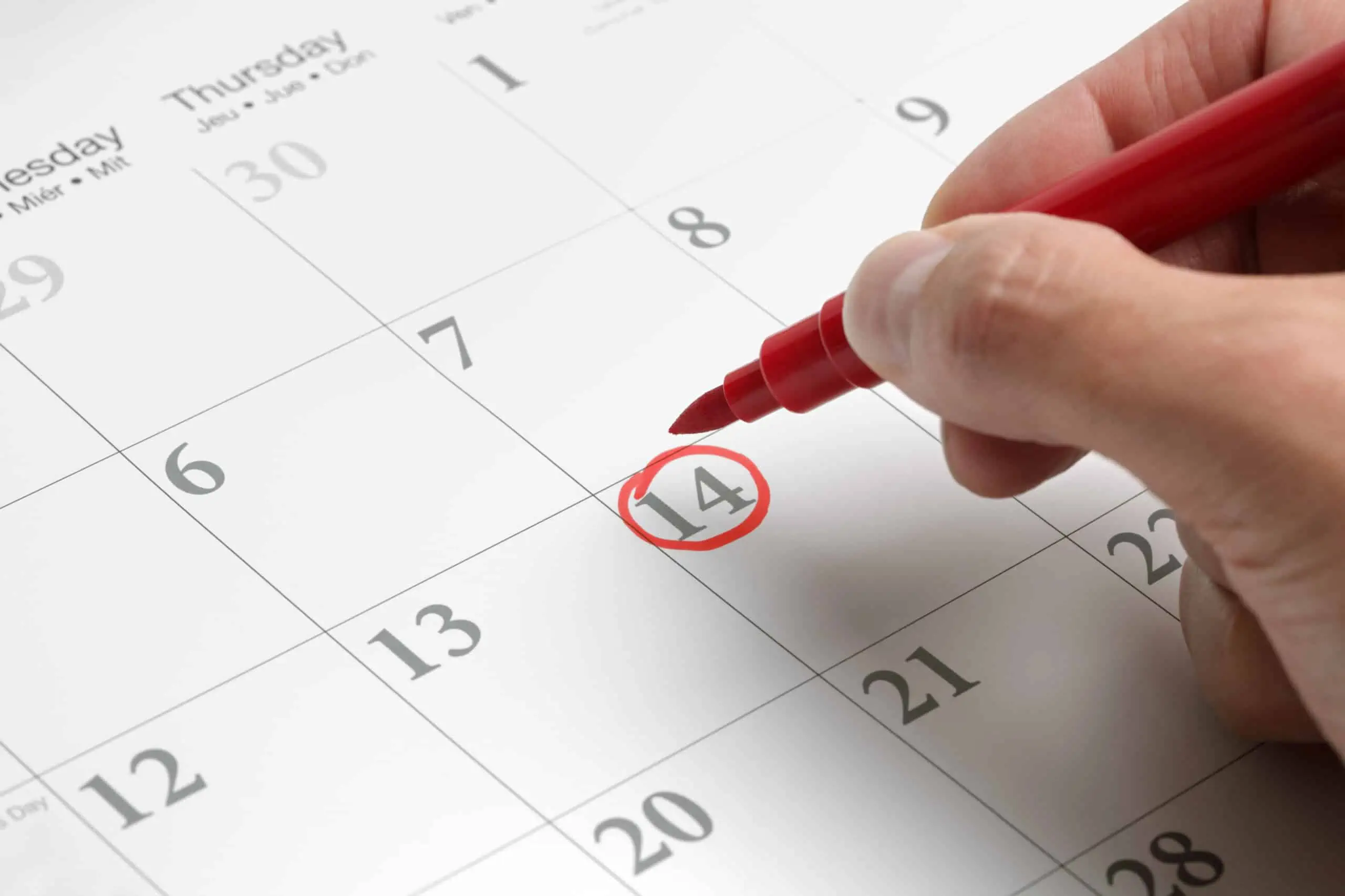 Circling the date on a calendar in red marker as a reminder to cancel free trials.