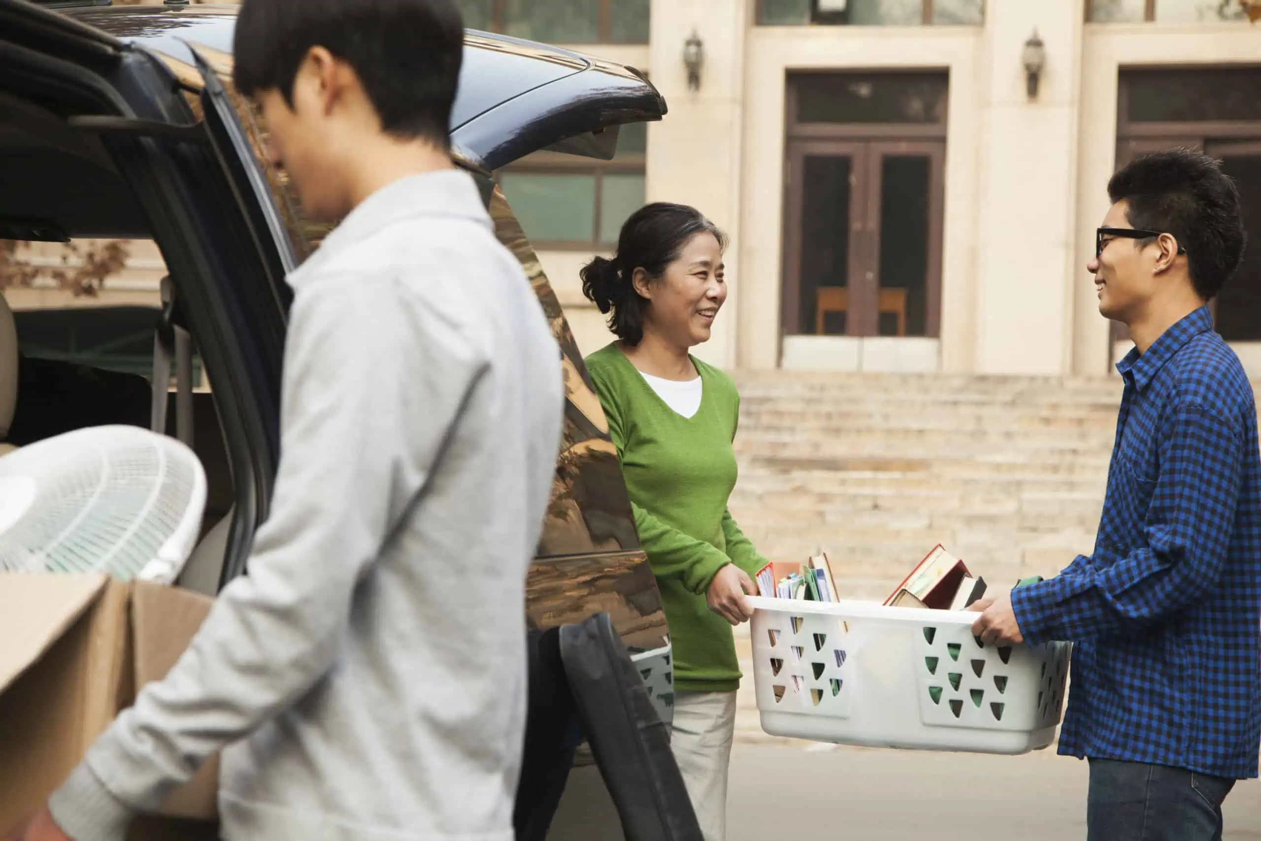 Chinese family moving their son into the dormitory on a college campus.