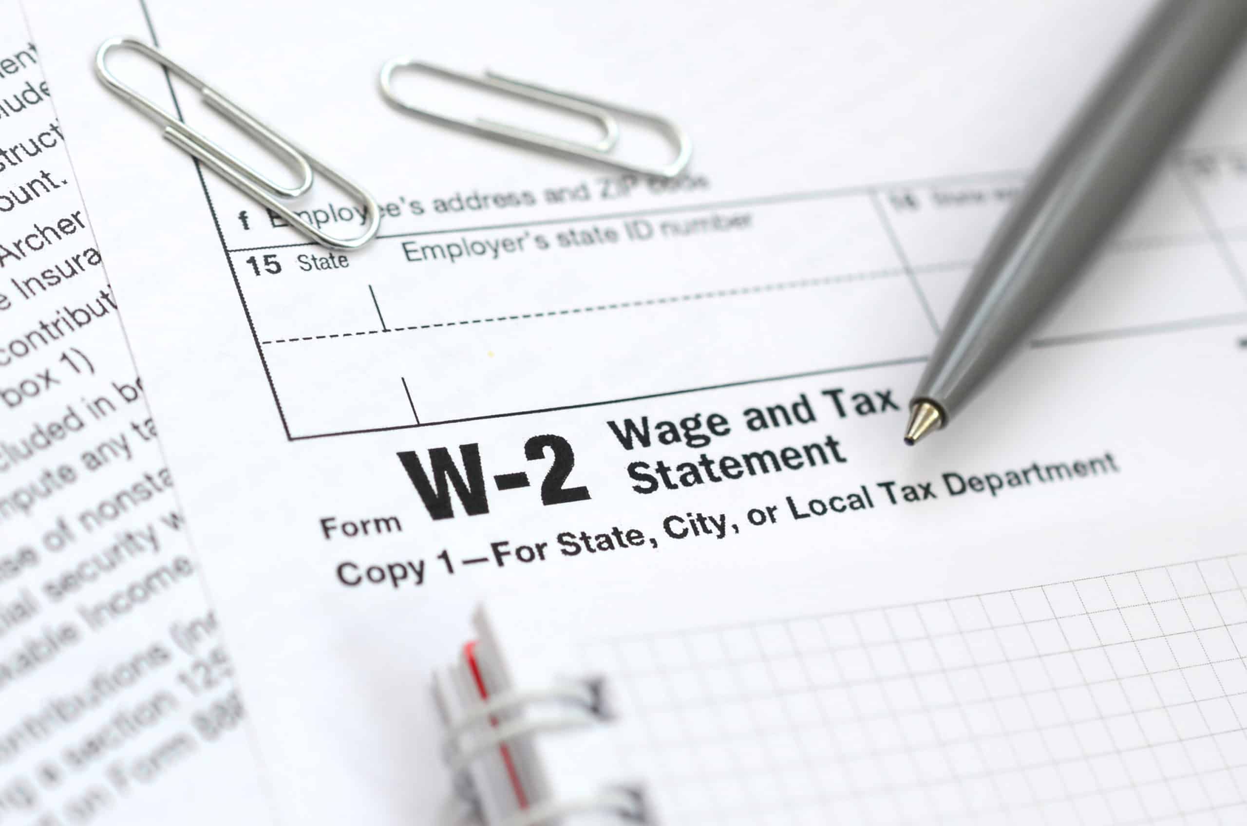 State income tax return copy of form W-2 Wage and Tax Statement pen and notebook